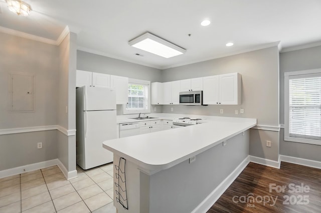 8731 Coralbell Ln, Charlotte, NC 28213 - kitchen with white appliances, a peninsula, crown molding, light countertops, and baseboards