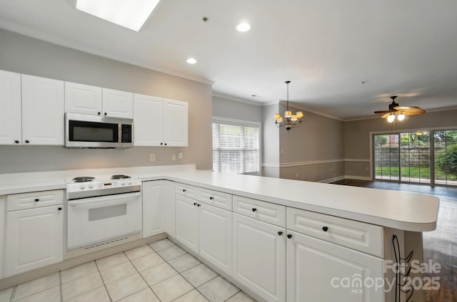 8731 Coralbell Ln, Charlotte, NC 28213 - kitchen with stainless steel microwave, electric range, a peninsula, crown molding, and a chandelier