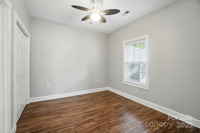 8731 Coralbell Ln, Charlotte, NC 28213 - unfurnished bedroom featuring dark wood-style flooring, a closet, baseboards, and a ceiling fan
