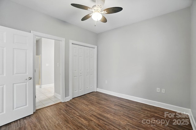 8731 Coralbell Ln, Charlotte, NC 28213 - unfurnished bedroom with dark wood-type flooring, baseboards, a closet, and ceiling fan