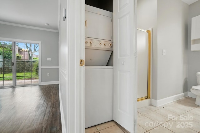 8731 Coralbell Ln, Charlotte, NC 28213 - laundry room with estacked washer and dryer, ornamental molding, baseboards, and light tile patterned floors