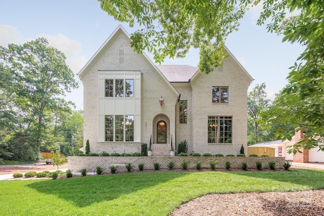 view of front of house with a front yard and brick siding