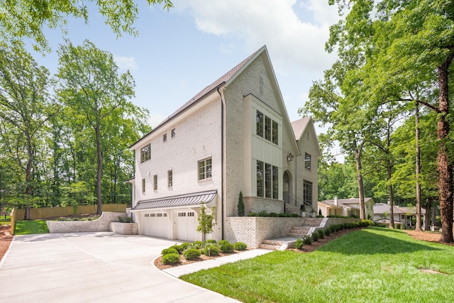 view of home's exterior featuring brick siding, an attached garage, driveway, and a lawn