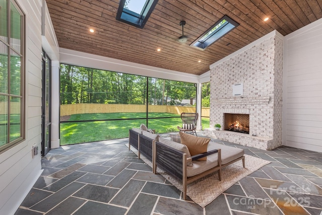 sunroom with a skylight and an outdoor living space with a fireplace