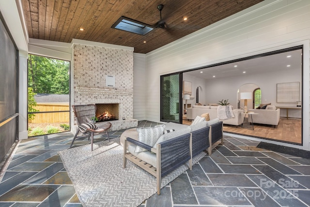 view of patio / terrace featuring an outdoor living space with a fireplace and fence