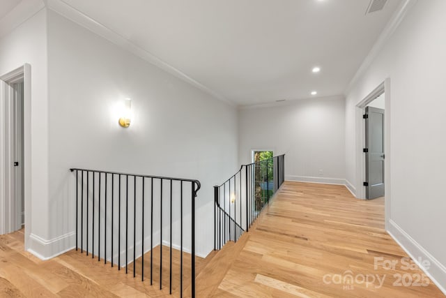 hall with an upstairs landing, wood finished floors, ornamental molding, baseboards, and recessed lighting
