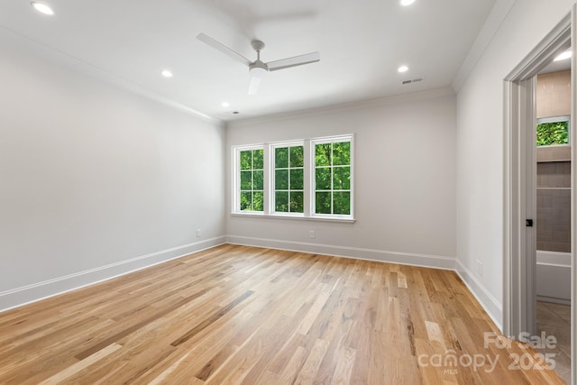 spare room featuring crown molding, light wood-type flooring, ceiling fan, baseboards, and recessed lighting