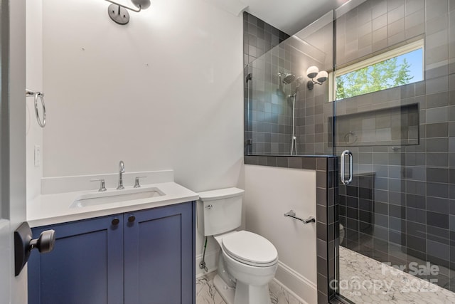 bathroom featuring toilet, a stall shower, vanity, and marble finish flooring