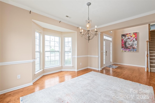 14104 Kendrick Cross Rd, Charlotte, NC 28273 - unfurnished room featuring a chandelier, wood finished floors, ornamental molding, baseboards, and stairs