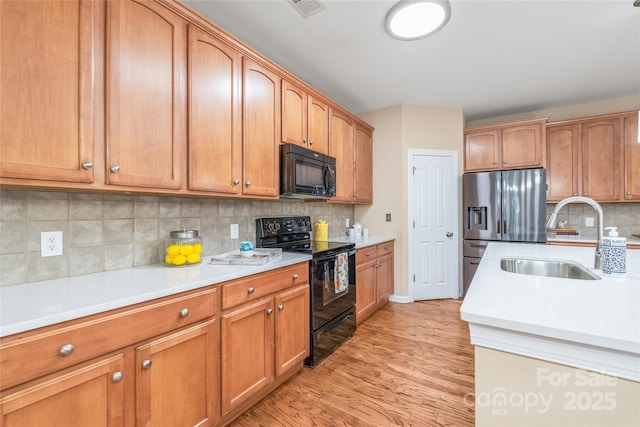 14104 Kendrick Cross Rd, Charlotte, NC 28273 - kitchen with black appliances, a sink, light countertops, and light wood-type flooring