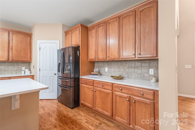 14104 Kendrick Cross Rd, Charlotte, NC 28273 - kitchen featuring stainless steel fridge, light wood-style floors, light countertops, backsplash, and brown cabinetry