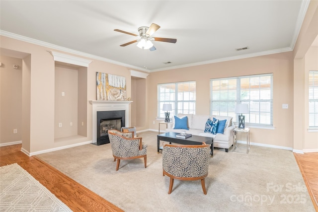 14104 Kendrick Cross Rd, Charlotte, NC 28273 - living area featuring ceiling fan, plenty of natural light, ornamental molding, a fireplace with flush hearth, and baseboards