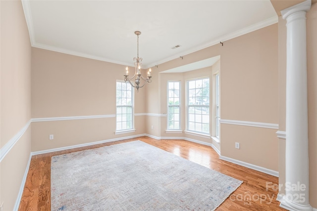 14104 Kendrick Cross Rd, Charlotte, NC 28273 - unfurnished room featuring decorative columns, a chandelier, wood finished floors, crown molding, and baseboards