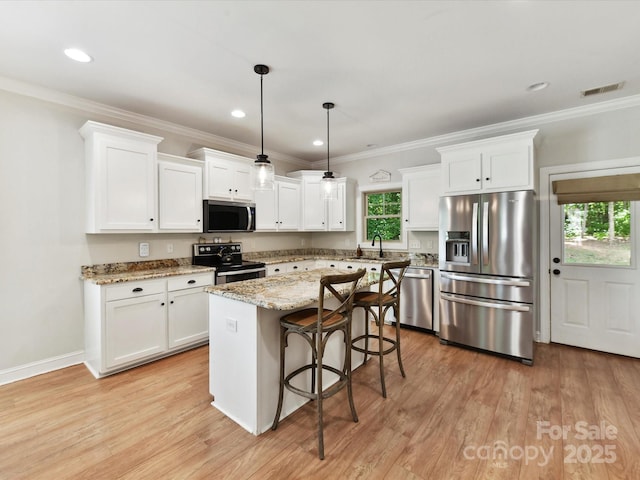 3801 Creek Ridge Dr, Denver, NC 28037 - kitchen with appliances with stainless steel finishes, plenty of natural light, white cabinetry, a kitchen bar, and ornamental molding
