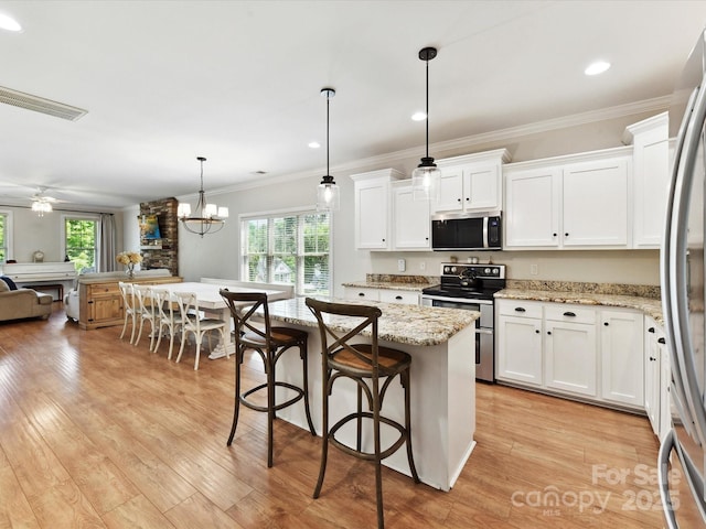 3801 Creek Ridge Dr, Denver, NC 28037 - kitchen with appliances with stainless steel finishes, plenty of natural light, white cabinetry, a breakfast bar, and crown molding