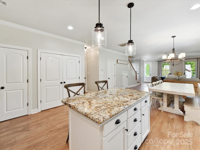 3801 Creek Ridge Dr, Denver, NC 28037 - kitchen featuring light wood-style flooring, ornamental molding, white cabinets, pendant lighting, and light stone countertops