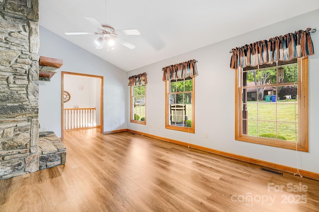 unfurnished living room featuring ceiling fan, wood finished floors, high vaulted ceiling, and baseboards
