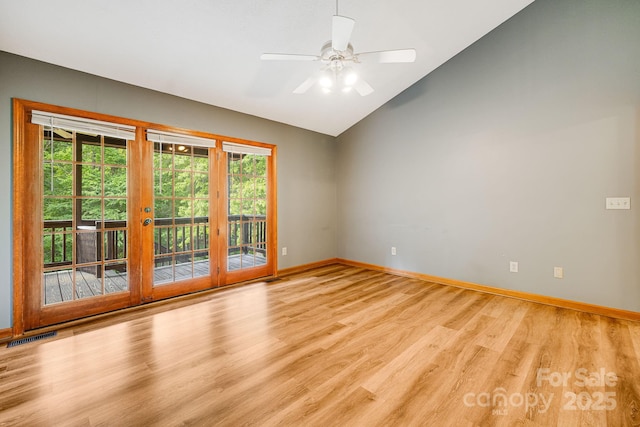 empty room featuring light wood-style flooring, lofted ceiling, baseboards, and a ceiling fan