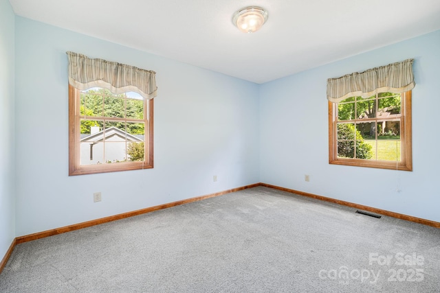 unfurnished room featuring carpet flooring and baseboards