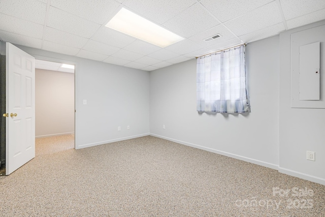 unfurnished room with a drop ceiling, carpet flooring, baseboards, and electric panel