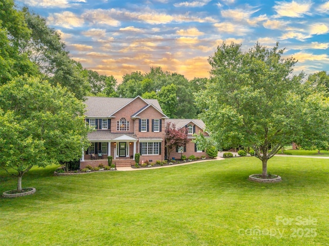 144 Chickasaw Dr, Shelby, NC 28152 - colonial home featuring covered porch, a yard, brick siding, and roof with shingles
