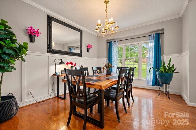144 Chickasaw Dr, Shelby, NC 28152 - dining space with a decorative wall, a chandelier, ornamental molding, wainscoting, and wood finished floors