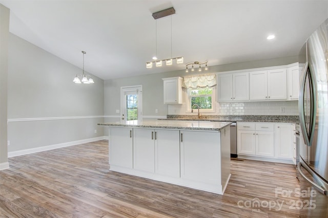 154 Stable Brook Ln, Taylorsville, NC 28681 - kitchen featuring stainless steel appliances, a chandelier, vaulted ceiling, backsplash, and white cabinetry
