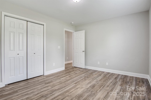 154 Stable Brook Ln, Taylorsville, NC 28681 - unfurnished bedroom featuring wood finished floors, a closet, and baseboards