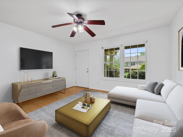 living area with a ceiling fan and wood finished floors
