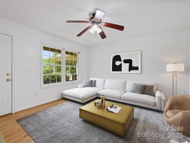 living room with wood finished floors, a ceiling fan, and baseboards