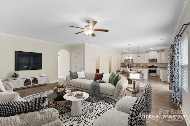 687 Cape Fear St, Fort Mill, SC 29715 - living room with light wood-style flooring, arched walkways, a ceiling fan, crown molding, and baseboards