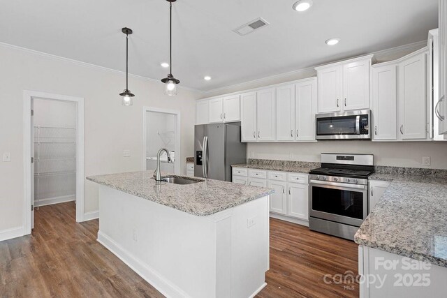 687 Cape Fear St, Fort Mill, SC 29715 - kitchen with stainless steel appliances, a sink, white cabinetry, a kitchen island with sink, and ornamental molding