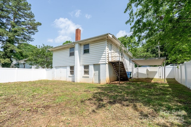 rear view of house featuring a chimney, stairs, brick siding, and a gate