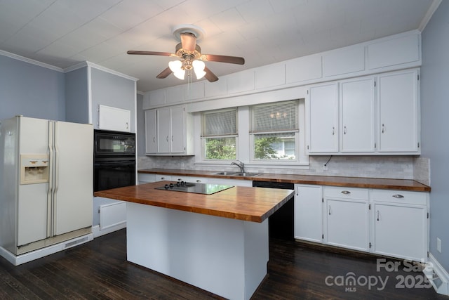 kitchen featuring butcher block countertops, black appliances, backsplash, white cabinetry, and crown molding