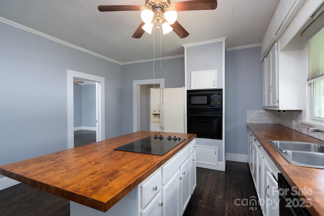 kitchen with wooden counters, black appliances, a sink, white cabinetry, and dark wood-type flooring