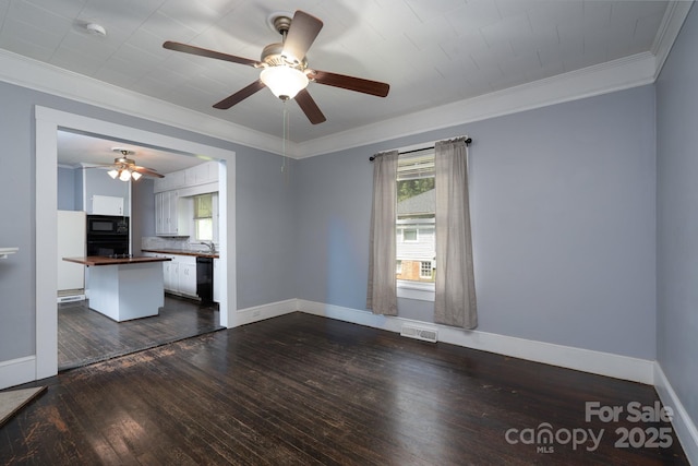 unfurnished living room with ceiling fan, ornamental molding, dark wood-style flooring, and baseboards