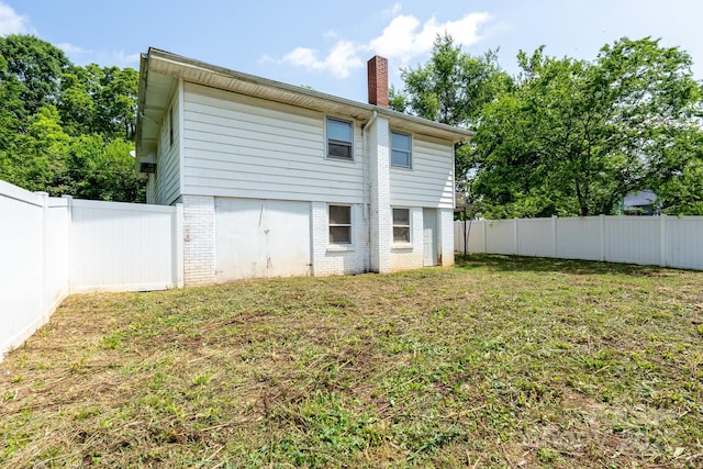 rear view of property with a chimney and brick siding
