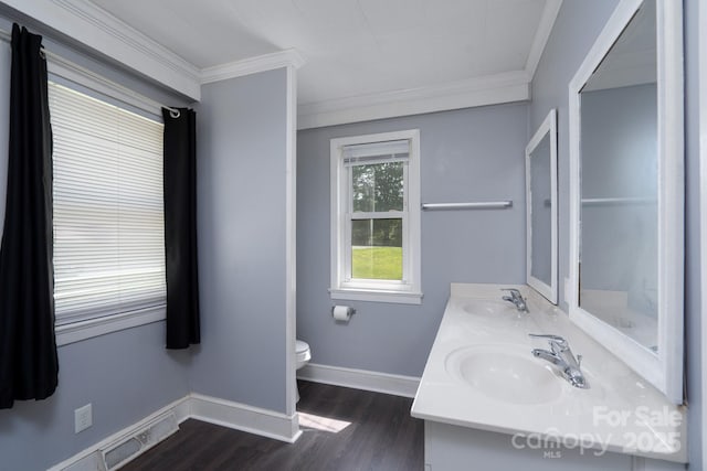bathroom with crown molding, wood finished floors, toilet, baseboards, and double vanity