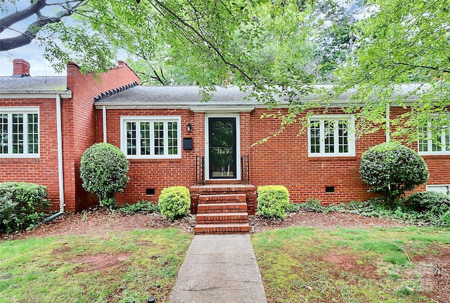 view of front of house with crawl space, brick siding, roof with shingles, and entry steps