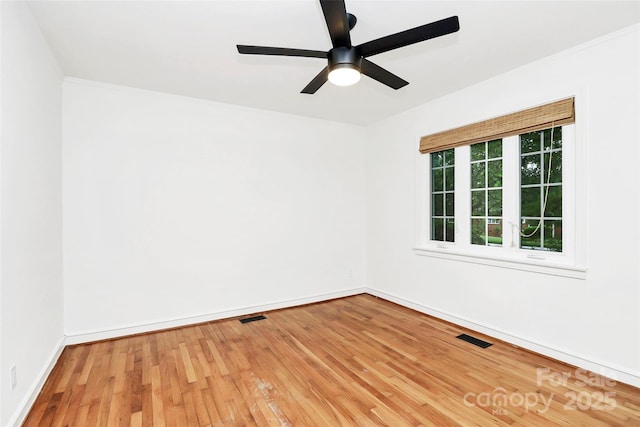 empty room with hardwood / wood-style flooring, ceiling fan, baseboards, and ornamental molding
