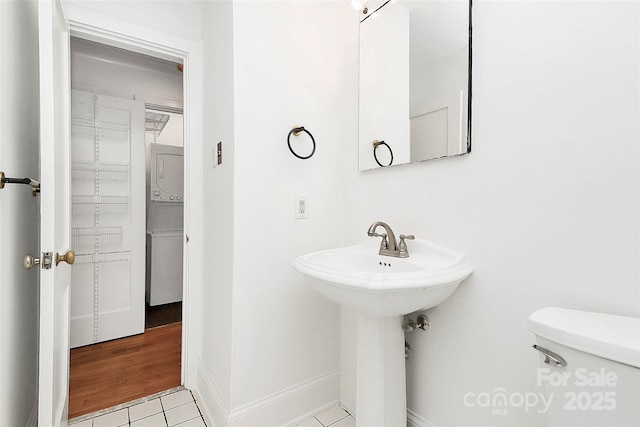 half bath featuring toilet, tile patterned flooring, and baseboards