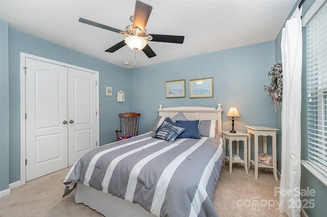 bedroom with light carpet, a closet, a ceiling fan, and baseboards