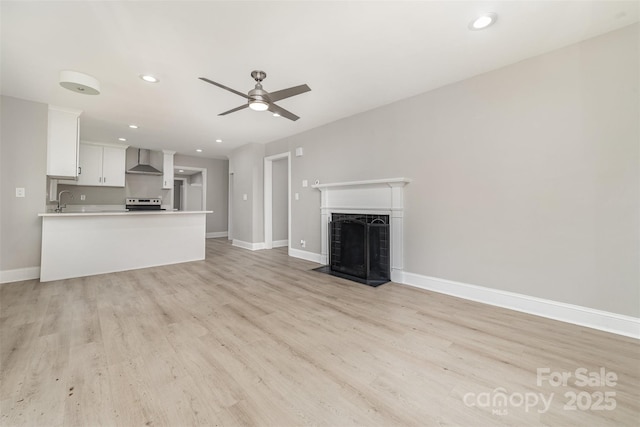 3920 Admiral Ave, Charlotte, NC 28205 - unfurnished living room featuring baseboards, ceiling fan, light wood-style flooring, recessed lighting, and a fireplace with flush hearth