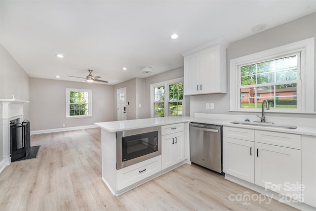 3920 Admiral Ave, Charlotte, NC 28205 - kitchen with dishwasher, built in microwave, a sink, a peninsula, and white cabinets
