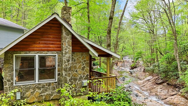 751 Millers Pond Ln, Boone, NC 28607 - view of side of home with stone siding, a chimney, and a forest view