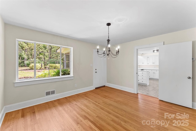 90 Pinewood Rd, Granite Falls, NC 28630 - unfurnished dining area with a chandelier, baseboards, and light wood-style flooring
