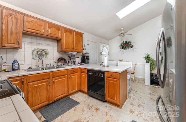 kitchen with black appliances, a sink, lofted ceiling, a peninsula, and decorative backsplash