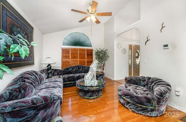 1076 Braxton Dr, Concord, NC 28025 - living room with vaulted ceiling, ceiling fan, arched walkways, and wood finished floors