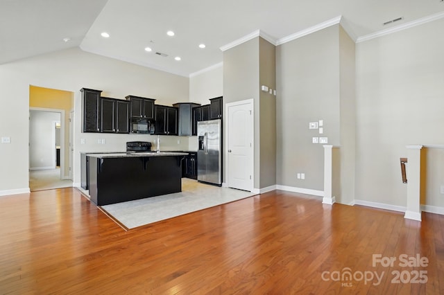 11209 Lazio Ln Unit 1, Charlotte, NC 28277 - kitchen featuring black appliances, dark cabinets, a towering ceiling, a breakfast bar area, and a center island