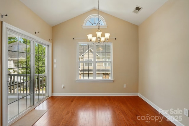 11209 Lazio Ln Unit 1, Charlotte, NC 28277 - unfurnished dining area with hardwood / wood-style floors, plenty of natural light, a chandelier, lofted ceiling, and baseboards